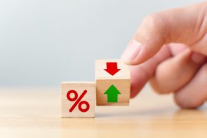 a percentage sign on a block with a hand flippin another block next it with a red arrow and green up arrow