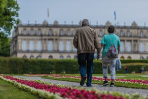an older couple holding hands and walking down a trail