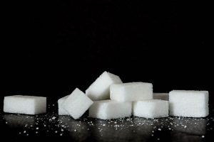 black background with white sugar cubes on a black table.