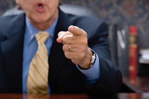 caucasian man in a suit pointing his finger while talking