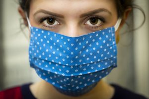 woman with a blue mask on with white polka dots