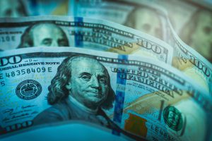 hundred dollar bills stacked in front of each other.