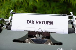 typewriter with the words tax return on the paper.