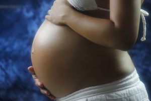 a large pregnant belly being held by the woman's hands.