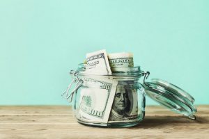hundred dollar bills inside a glass jar.