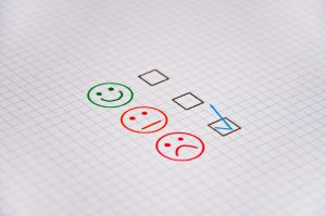 a green smile face, orange straight face and red sad face with a checkmark in the box next to the red one.
