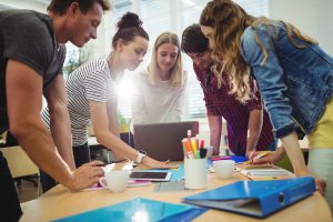 group of people gathered around a table looking at a piece of paper