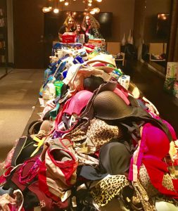 hundreds of different colored bras on a long table.