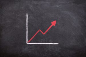 graph on a chalkboard with a red arrow going upward