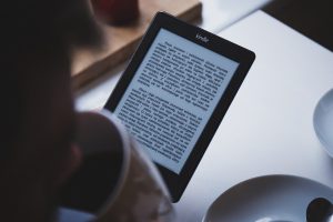 person holding a tablet with paragraphs on it.