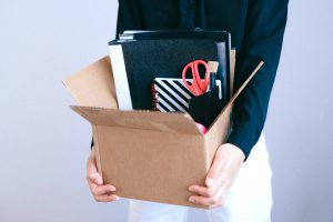 person carrying a box of office supplies.