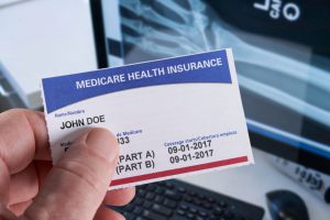 medicare card with the name john doe on it and an x-ray in the background
