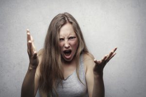 caucasian woman with her arms up yelling