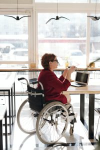 caucasian woman sitting in a wheelchair at a table