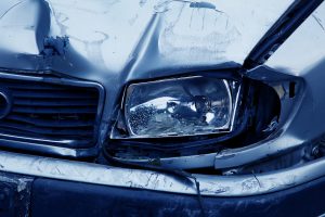 close up picture of a car's front bumper that is smashed up.