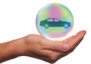 hand with a car in a fluorescent bubble.