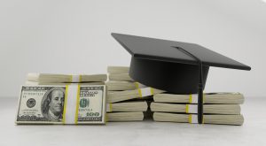 graduation cap on top of stacks of hundred dollar bills