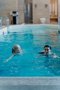 older woman and younger woman swimming in a pool