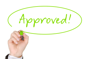approved written in green sharpie with a circle around it and a hand holding a green sharpie