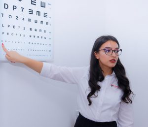 woman in glasses pointing at a eye chart