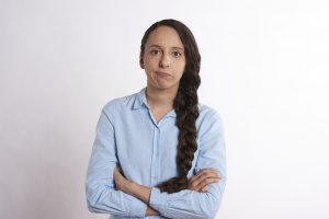 woman with a blue button up with a rude look on her face