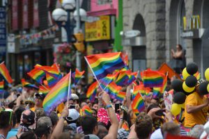 people in the street holding rainbow flags 