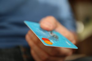 person with a blue credit card in their hand