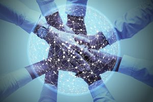 hands piled on top of each other with a network around it