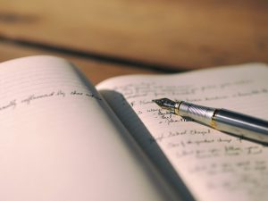 notebook open with a pen on top