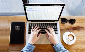 hands on a keyboard of laptop with a spreadsheet on the screen