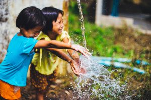 two young asian kids playing with water