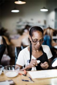 african american woman with an apron on and tools in her hand