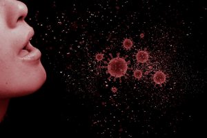 person sneezing with red viruses spreading out