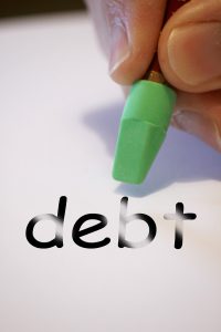 the word debt with a green eraser getting rid of the word.