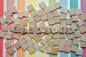 equality written in scrabble letters with a colorful background 