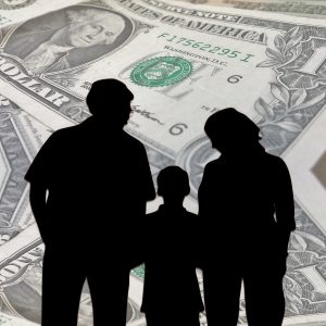 silhouette of people holding hands with a child in the middle and money bills as the background.