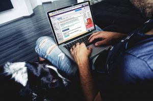 laptop on someone's lap scrolling through yahoo news