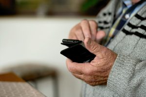 person holding a phone dialing on it