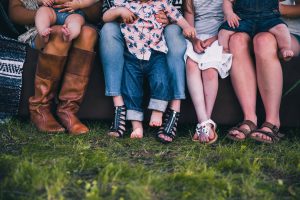 a group of people's legs sitting next to each other.
