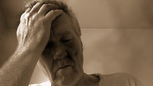 older caucasian man with his hand to his head