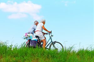 two older adults riding bicycles next to each othercyc