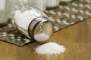 a salt shaker fallen over with salt spilling out