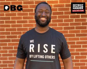 Khali Sweeney smiling with a red brick wall background