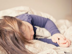 young caucasian kid sleeping in a bed