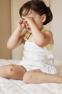 young caucasian girl sitting down rubbing her eyes