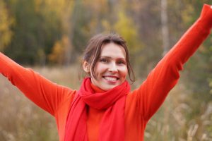 caucasian woman smiling with her hands up