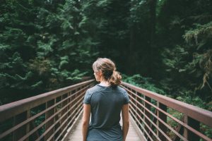 the back of a woman walking on a bridge