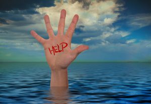 handing sticking out of water with the word help written on it
