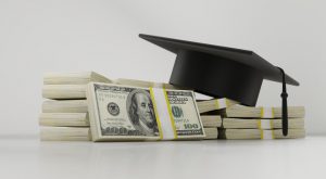 black graduation cap laying on top of stacks of money