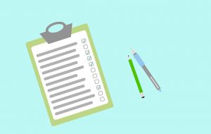 questionnaire on a clipboard with pens next to it